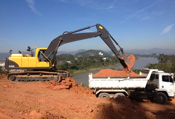 Escavadeira carregando caminhão basculante com terra